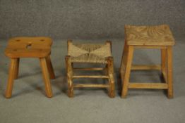 A collection of three stools, including an elm example with a shaped seat and hand hole, a stool