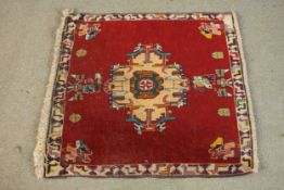 A Persian Sirjan rug with central stylised medallion on a madder field within a floral border. L.