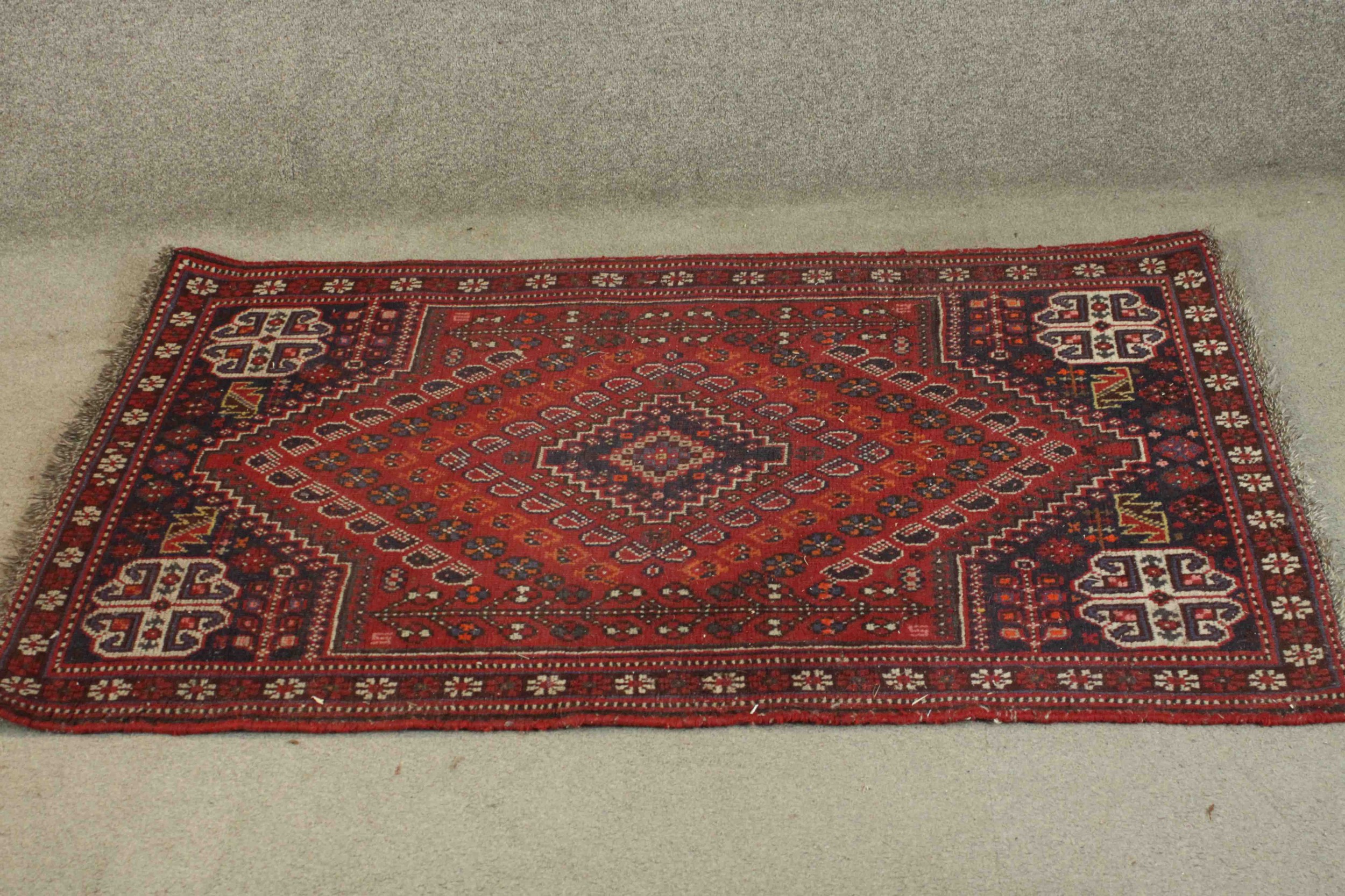 A Persian Shiraz the central medallion with stylised floral motifs on a burgundy ground within