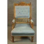 A late 19th century walnut armchair, with a carved top rail, upholstered to the arms, seat and