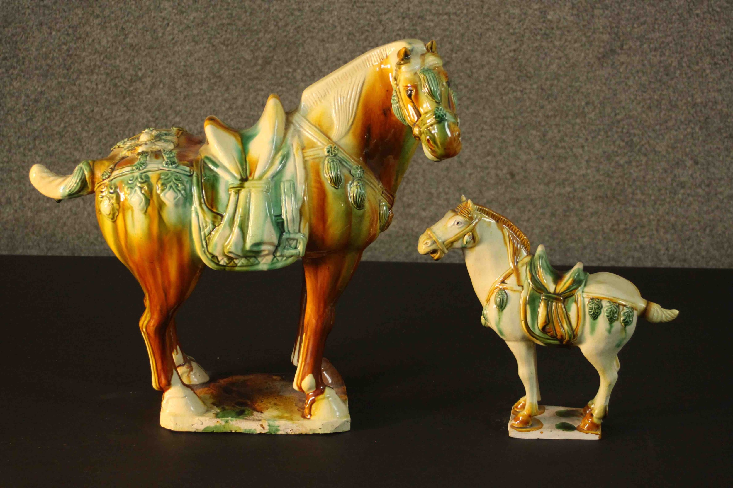 Two Tang dynasty style ceramic horses with applied green and ochre glazes. H.40 W.43 D.18cm. (