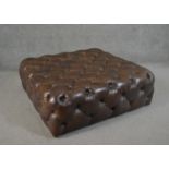 A contemporary brown deep buttoned leather hearth stool. H.33 W.100 D.100cm