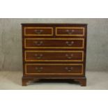 A 20th century Sheraton style mahogany and satinwood inlaid chest, the crossbanded top centred by an
