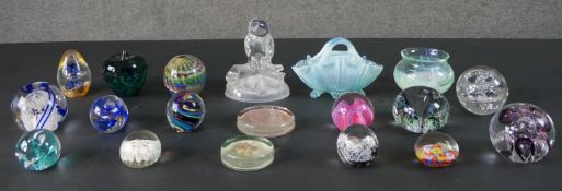 A collection of glass, including seventeen art glass paperweights, a blue opalescent glass basket