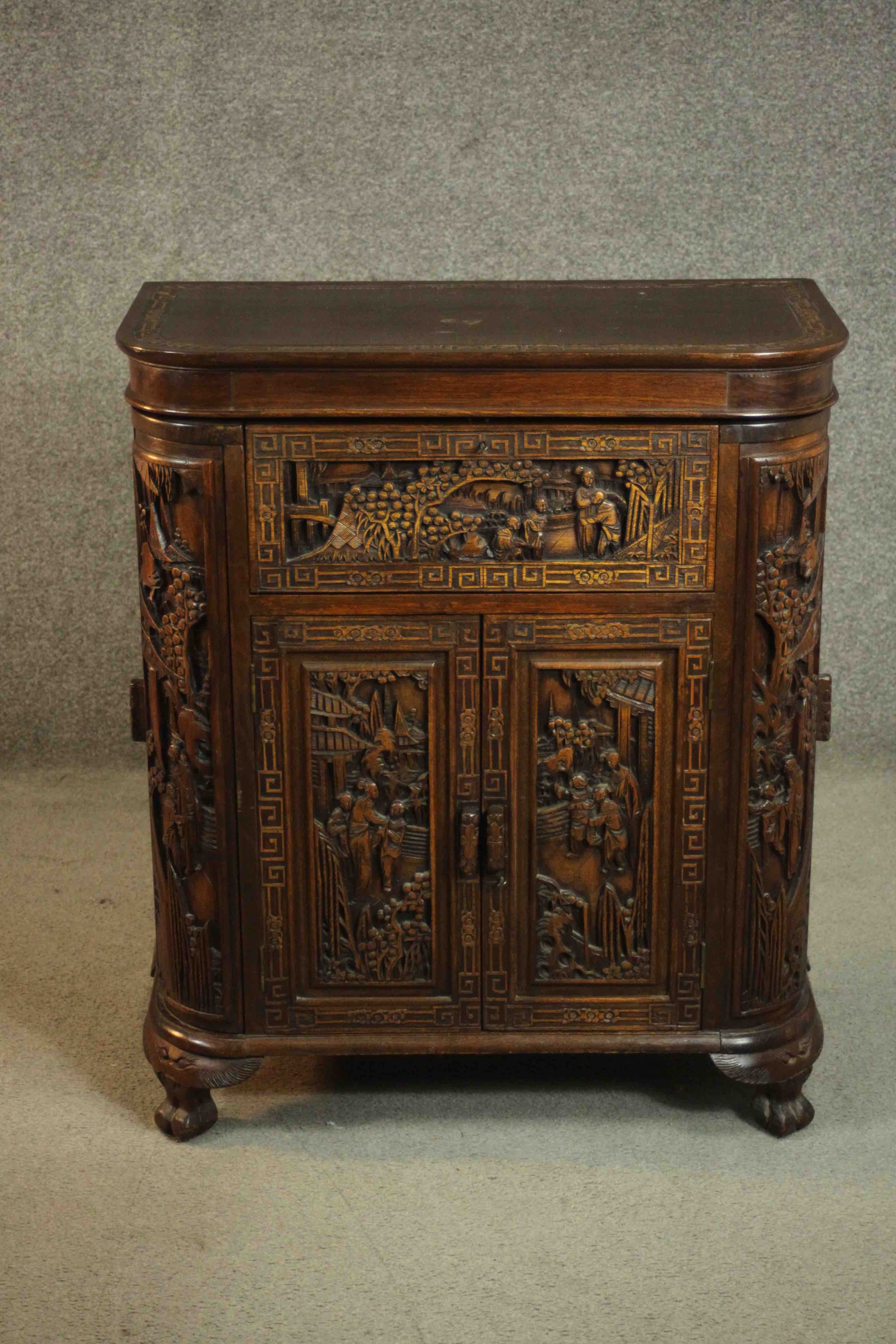 An early 20th century Chinese carved hardwood cabinet with central fitted drinks section. H.87 W.