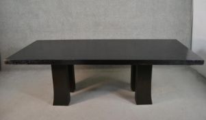A contemporary ebonised ash dining table, the rectangular top on square section legs with flared