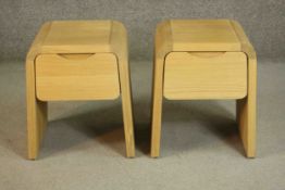 A pair of contemporary oak bedside tables, of inverted U shape with a single drawer and a recessed
