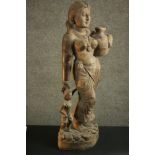 A 20th century carved figure of a woman holding her child's hand and carrying a water vessel. H.78