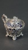 A pierced sterling silver Victorian sugar bowl with flower form finial and shell motifs to the