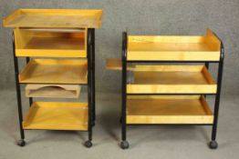 Two late 20th century birch ply artist's trolleys, with black powder coated metal frames on black