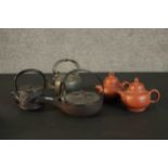 A collection of five Oriental tea pots, including two yixing clay tea pots and three cast iron