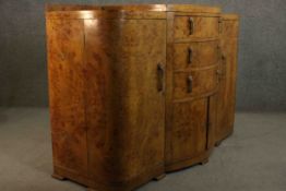 An Art Deco burr walnut sideboard with central bow fronted section fitted with drawers and doors