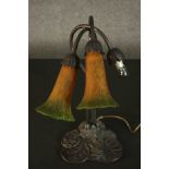 A reproduction Art Nouveau style table lamp, with two amber and green trumpet form glass shades,