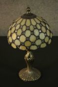 A Tiffany style table lamp, with a leaded stained glass shade on a bronzed metal base.