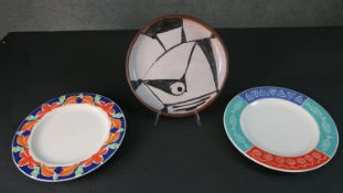 A large art pottery black and white plate along with two Syracuse plates. Diam.31cm (largest)