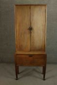 An Art Deco walnut tall cabinet with panel doors above fall front base cupboard. H.175 W.66 D.33cm.