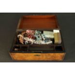 A burr walnut veneered writing box filled with a collection of costume jewellery. H.15 W.35 D.23cm.
