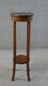 An Edwardian walnut jardiniere stand, with a circular line inlaid top over a circular undertier with