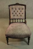 A late Victorian walnut nursing chair, with a carved top rail over a buttoned back and turned