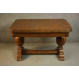 A circa 1940s oak draw leaf dining table, with two leaves, on carved bulbous legs joined by H