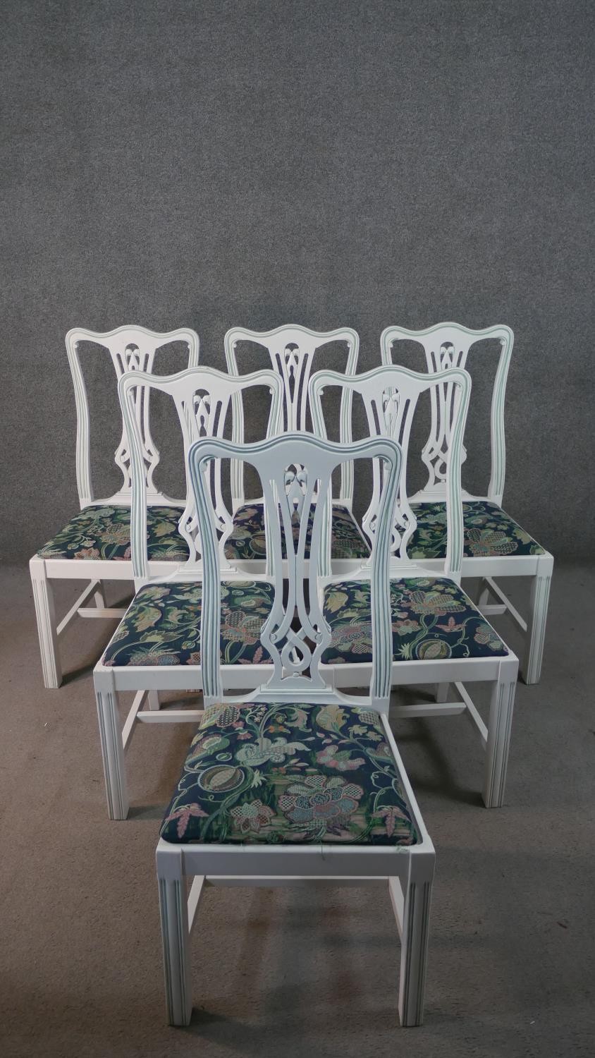A set of six white painted Chippendale style dining chairs with drop in seats on square supports.