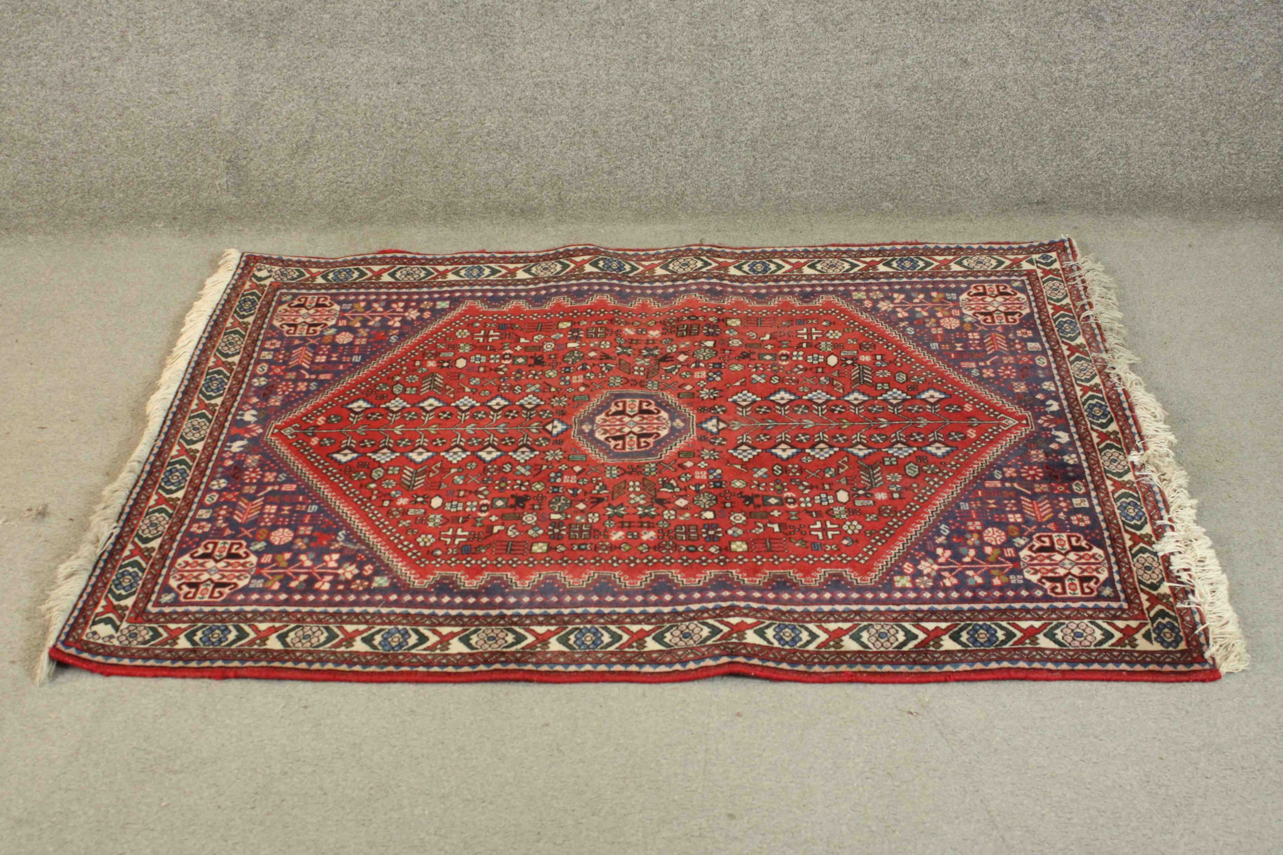 A Persian Bidjar rug the central medallion with stylised floral design within spandrels and multiple
