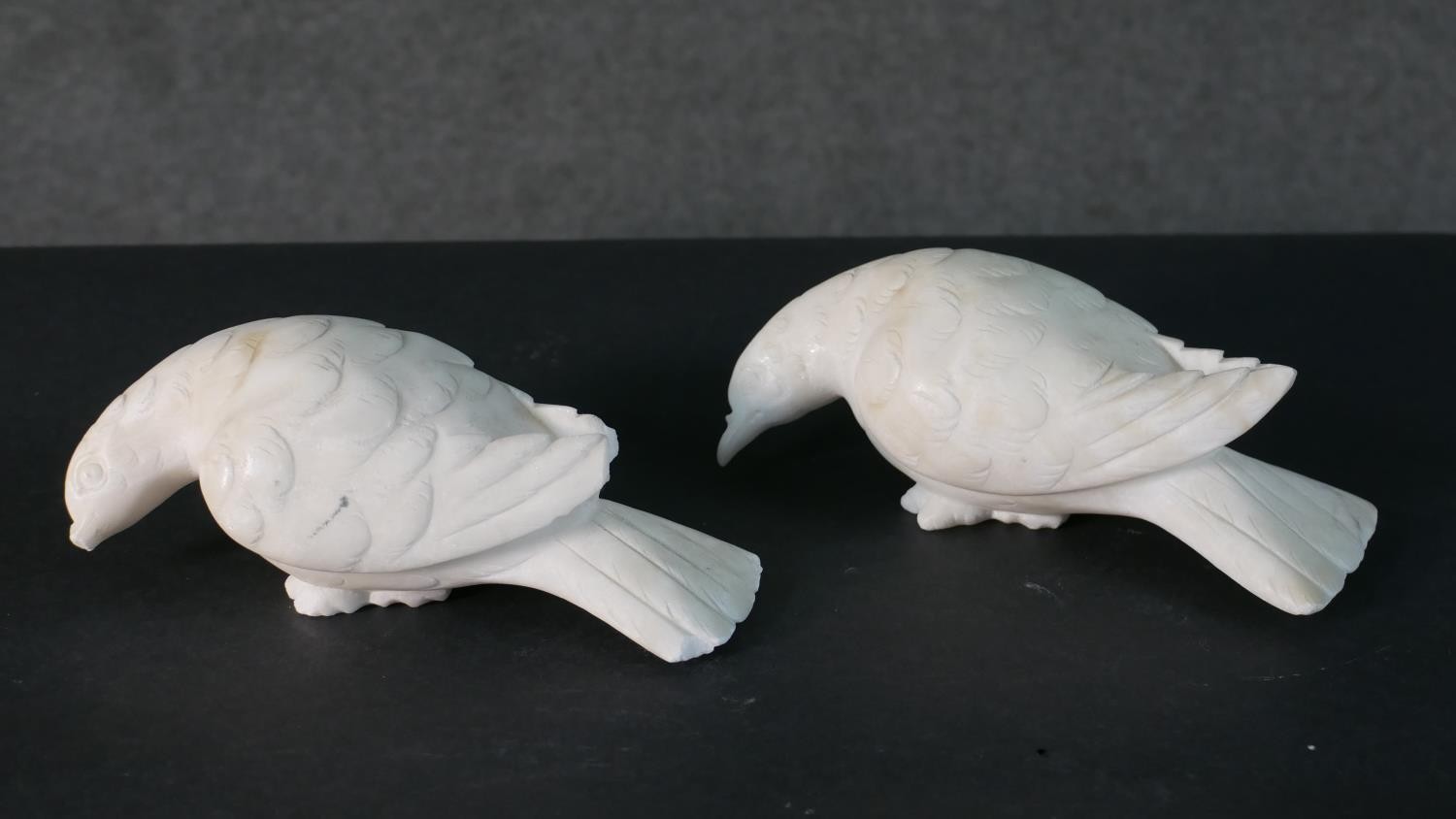 A pair of carved white marble doves. (beak broken)H.8 W.18cm