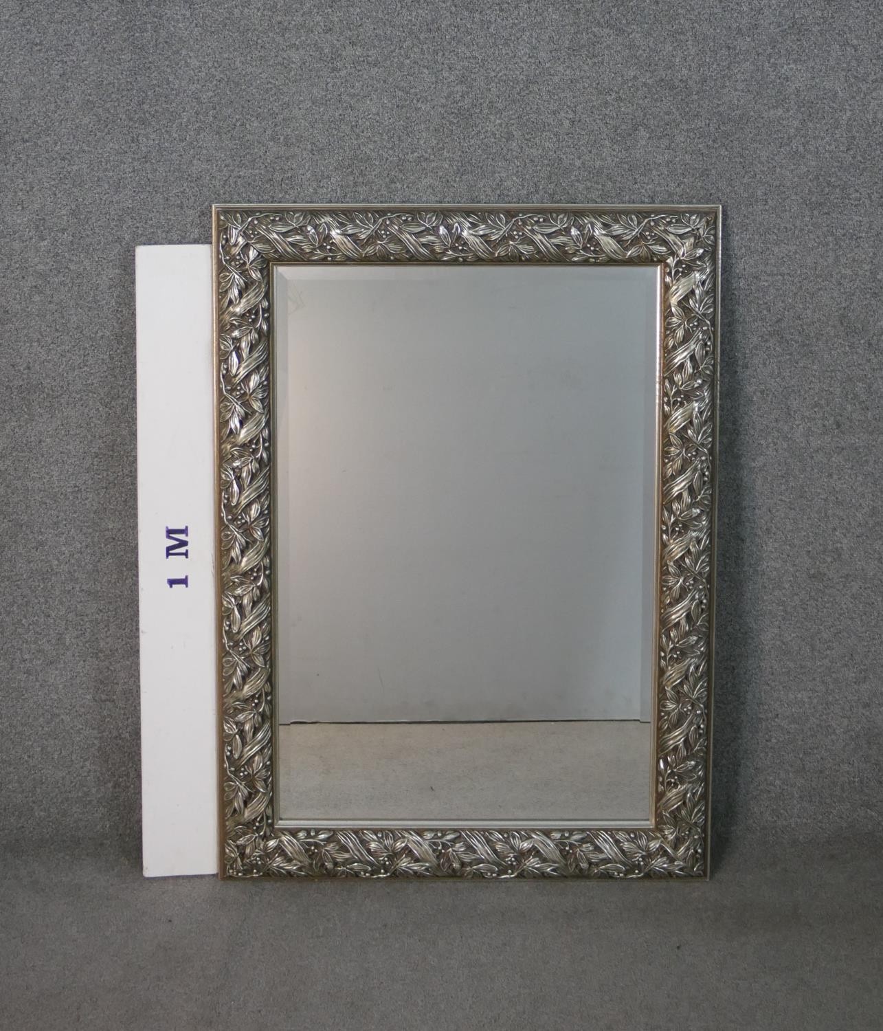 A silver painted moulded foliate and ribbon design wall mirror. H.107 W.78cm - Image 2 of 4