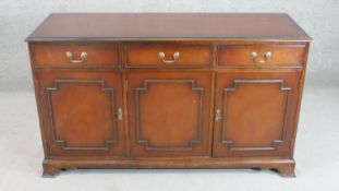 A reproduction George III style mahogany sideboard, the rectangular top over three short drawers and