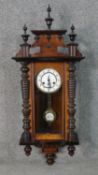 A late 19th century walnut cased Vienna regulator with Roman numerals on a white enamel dial. The