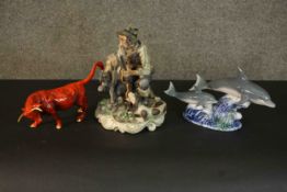 A collection of hand painted porcelain, including a red glaze bull and a pair of dolphins among