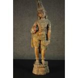 A large carved and painted 19th century Oriental statue of a deity standing on a lotus form base.