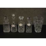 Four cut crystal decanters and a trumpeting form cut crystal vase. Three decanters with ceramic