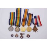 A collection of five WW1 medals along with four military badges. Three medals for 14761 PTE E.