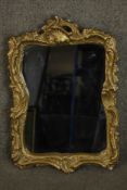 A 20th century rococo revival gilt plaster mirror, of waisted form with the frame moulded with