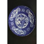 A large 19th century Japanese blue and white scalloped edge ceramic charger with transfer design