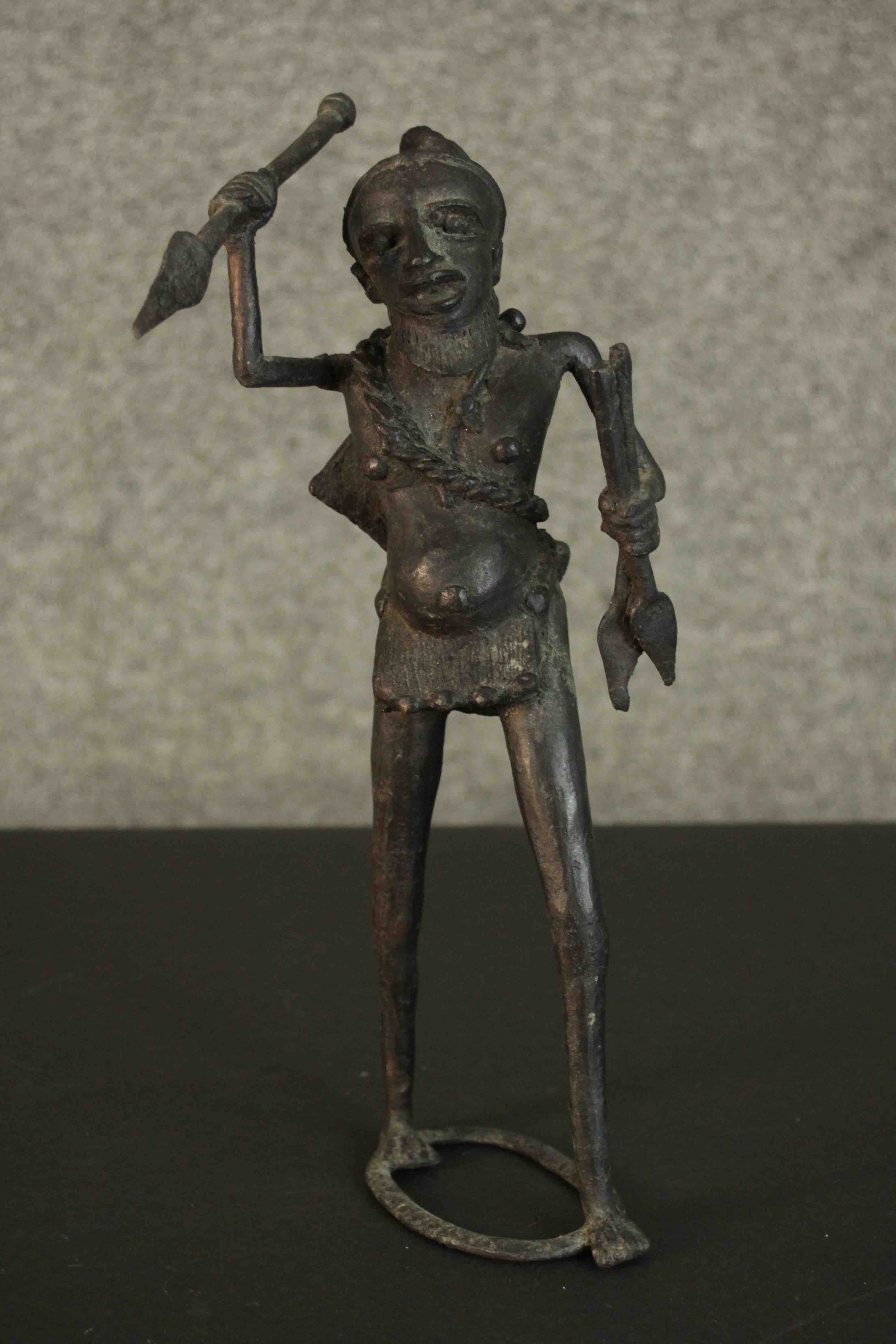 An African tribal bronze figure of a warrior throwing a spear. H.31 W.12cm