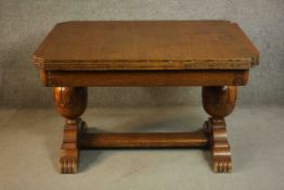 A circa 1940s oak draw leaf dining table, with two leaves, on carved bulbous legs joined by H