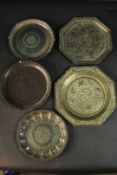 A collection of five 19th century Indian engraved brass plates, each with a different design. One