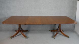 A Regency style mahogany D-end extending dining table with two additional leaves on quatraform bases