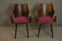 A pair of vintage Czechoslovakian tub armchairs, with curved plywood back over open arms and