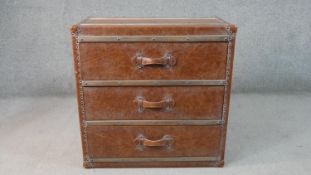 A leather clad campaign style chest of three long drawers with twin carrying handles. H.76 W.76 D.