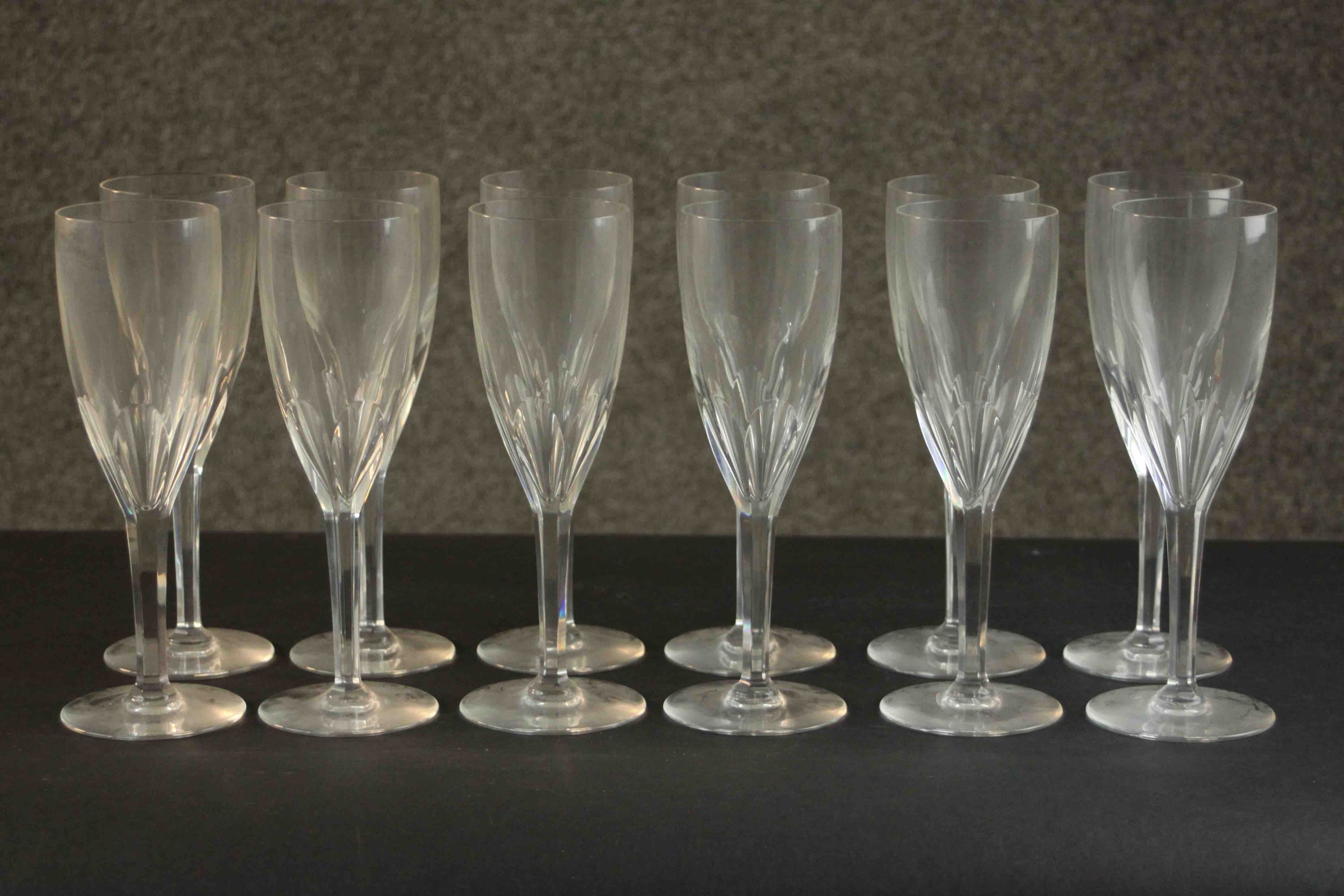 A set of twelve hand cut Baccarat crystal petal faceted champagne flutes, etched maker's stamp to