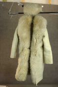 A large sheepskin coat with Cossack style hat, fastens with leather belts. To fit a male size large.