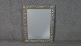 A moulded Art Nouveau lily design framed wall mirror with chamfered glass. H.76 W.60cm