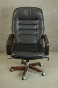A circa 1970s Danish Dyrlund swivel desk chair, with open arms, upholstered in black leather on a