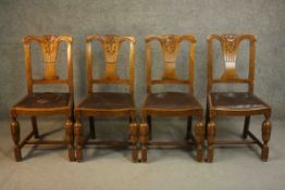 A set of four circa 1940s oak dining chairs, with a carved splat back over a brown faux leather drop