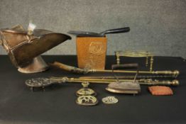 A collection of metal ware, including horse brasses, a trivet, a copper coal scuttle, brass fire