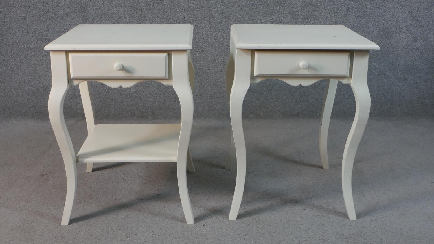 A pair of French style painted bedside tables, with a square top over a single drawer on cabriole