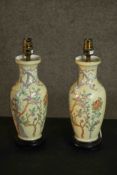 A pair of Chinese Famille Rose baluster table lamps, decorated with foliate designs, on ebonised